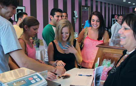 A group of people standing around at a table.